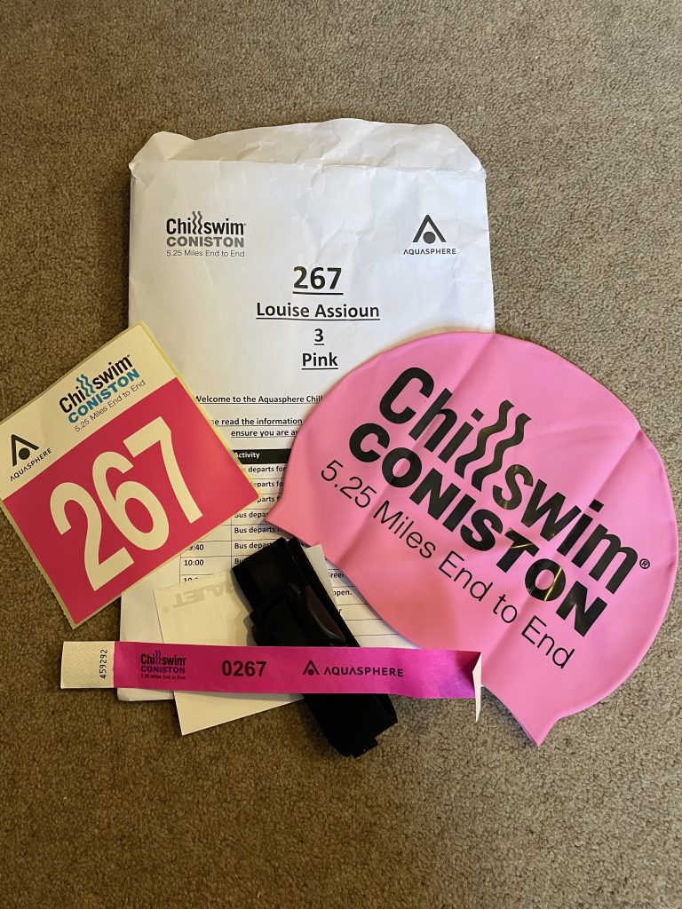 Lou's entry pack including the pink swim hat, entry number and timing band