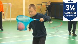 School pupil hitting a ball out of a catching net with his hand